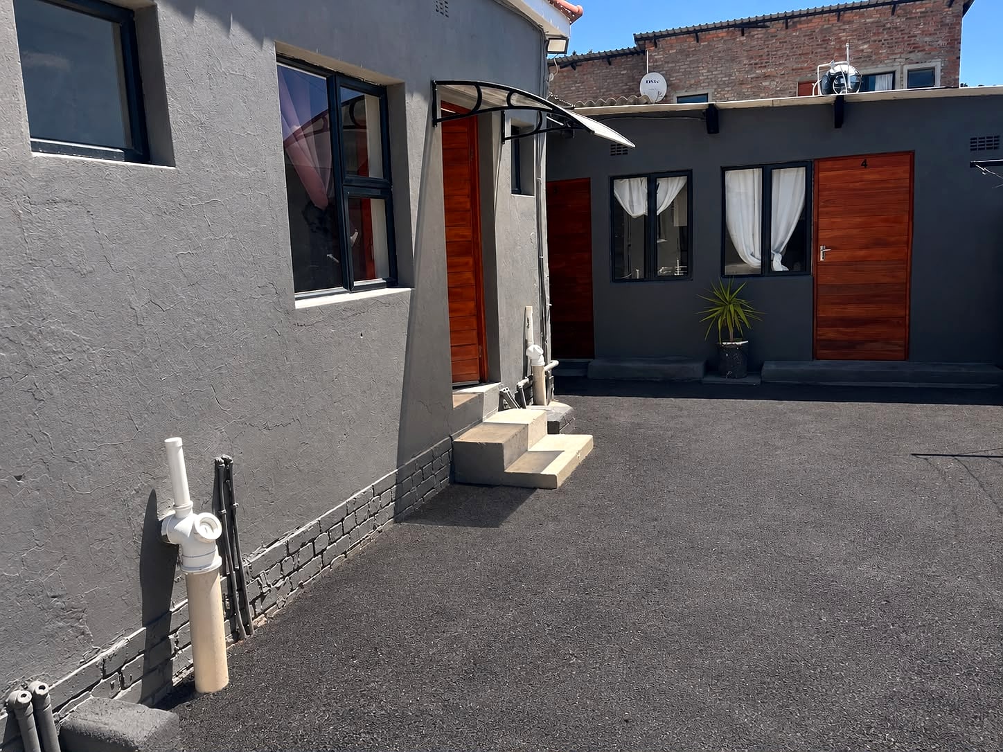 The paved yard at 12A Durham Street, with the room doors along it