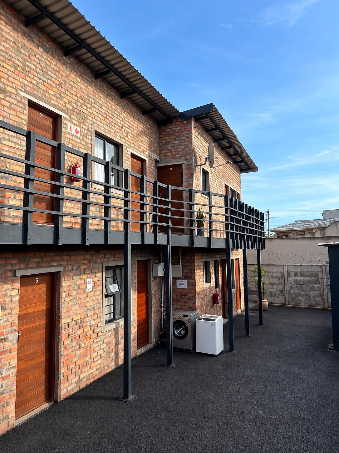 The two-storey face-brick block at 12B with its balcony walkway