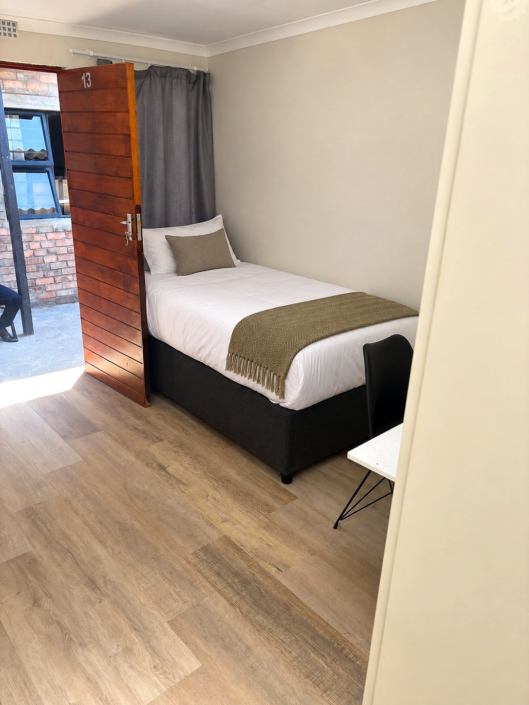 A private single room at 12B, seen from its front door
